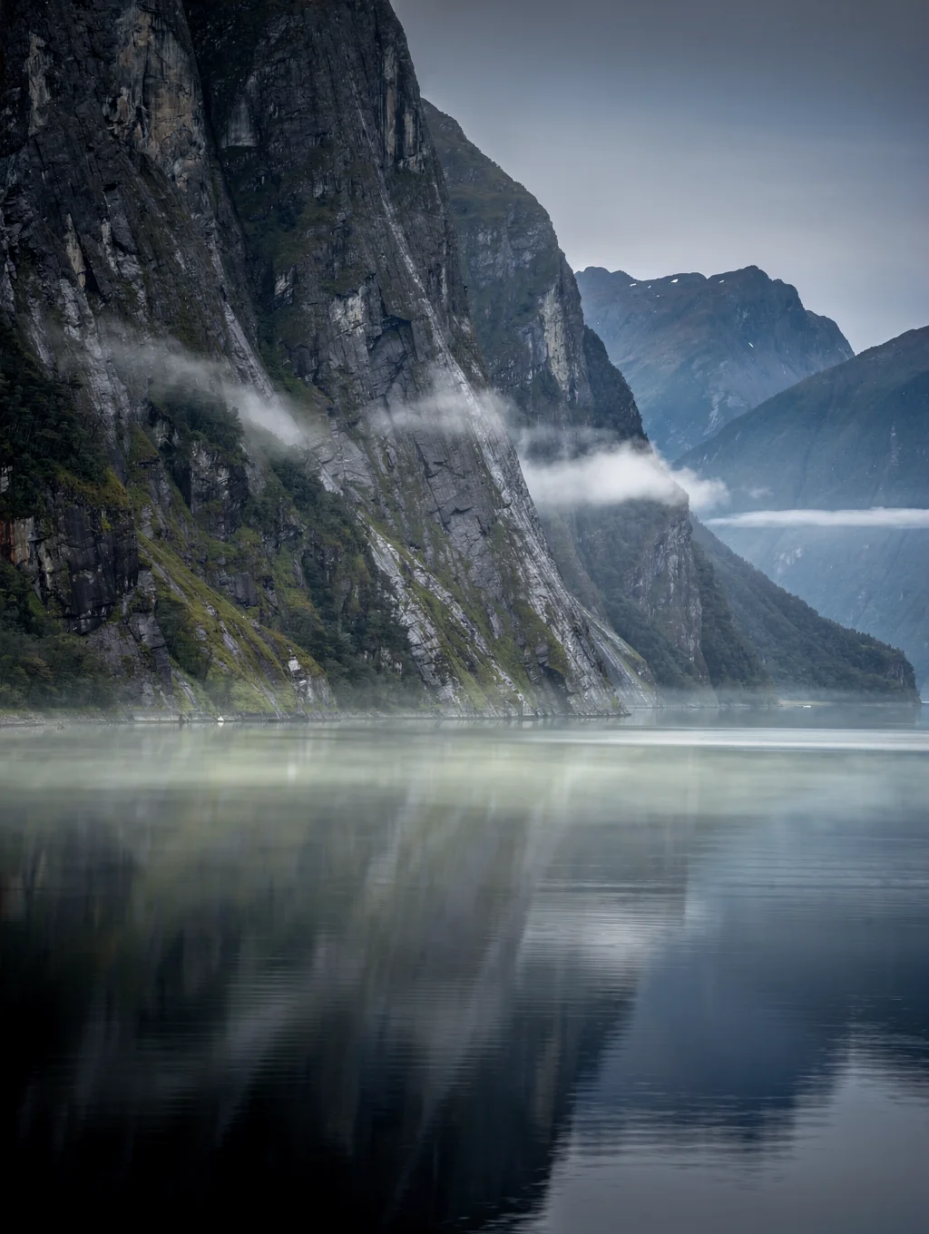 Sheer fjord walls rising from dark water